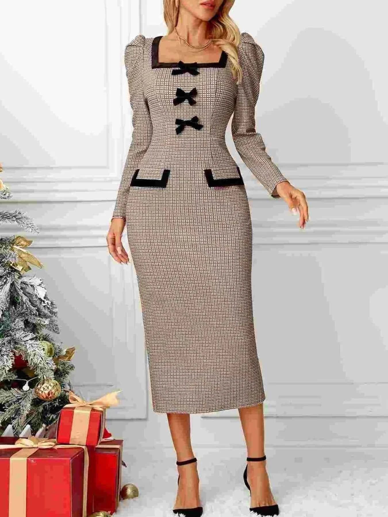 Woman wearing a patterned dress with black bows in front of a Christmas tree and presents.